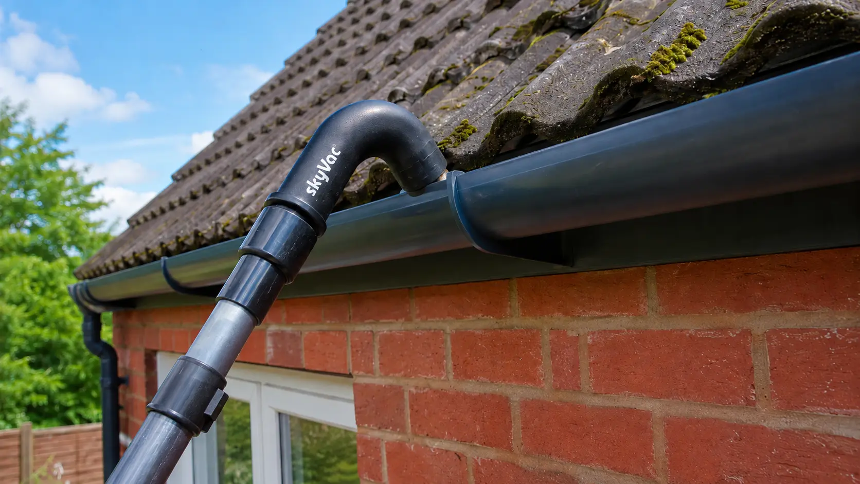 Cleaning a gutter using a gutter vaccuum.
